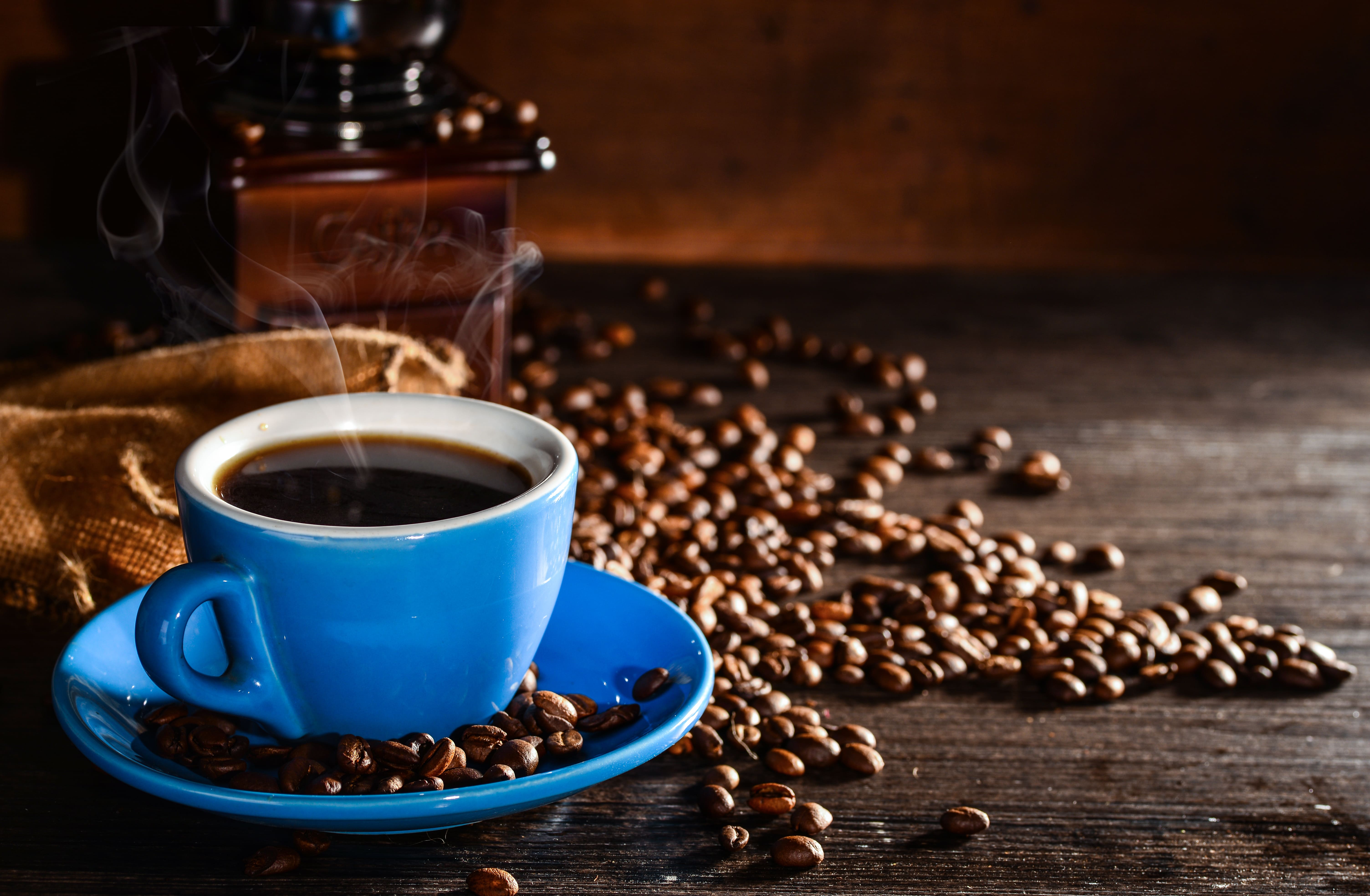 cup of coffee with coffee beans and grinder background 1 site