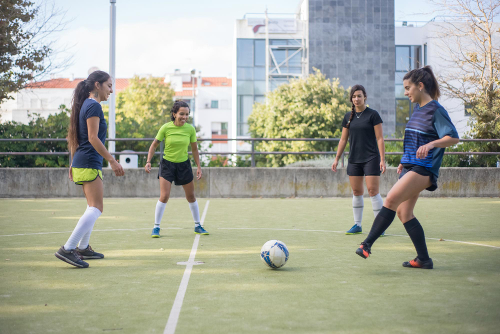 sporty young women training on football field sportswomen in colorful uniforms standing in circle kicking ball warming up sport leisure active lifestyle concept