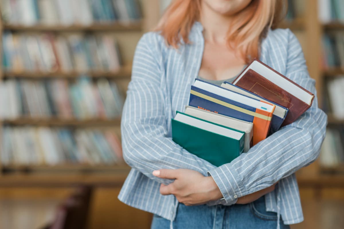 adolescente de colheita abracando livros 1